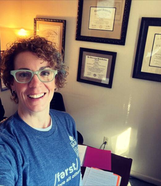 Dr. Heather Hawn in her office in front of a wall with diplomas.
