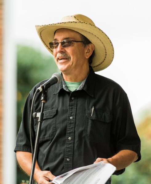 man in a cowboy hat at a podium