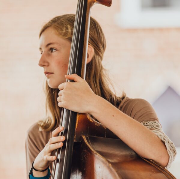 Closeup of a young woman playing the upright bass.