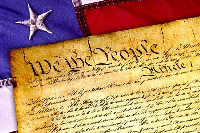 Portion of the U.S. Constution overlaying a U.S. flag.
