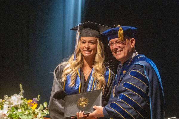 Caroline Rizzo of Flagler Beach, Florida; political science major and Heritage Student, receives her diploma from President Tony Floyd
