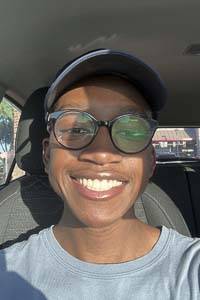 AJ Rivers, sitting in a car, wearing glasses and a ballcap