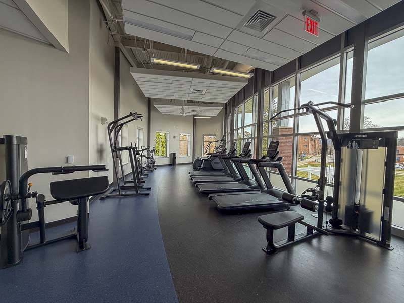 Ellen Fitness Center, looking to the north, with cardio equiment on the right in front of floor-to-ceiling windows.