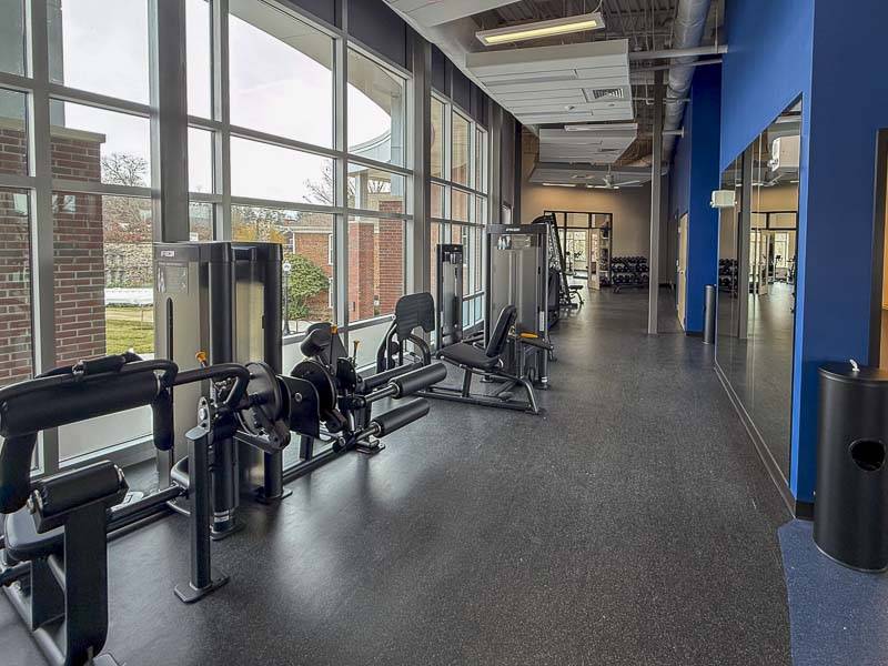 Ellen Fitness Center, looking to the south, with weight machines to the left in front of floor-to-ceiling windows.